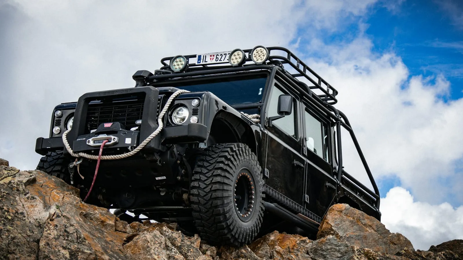 A black jeep is parked on a rock