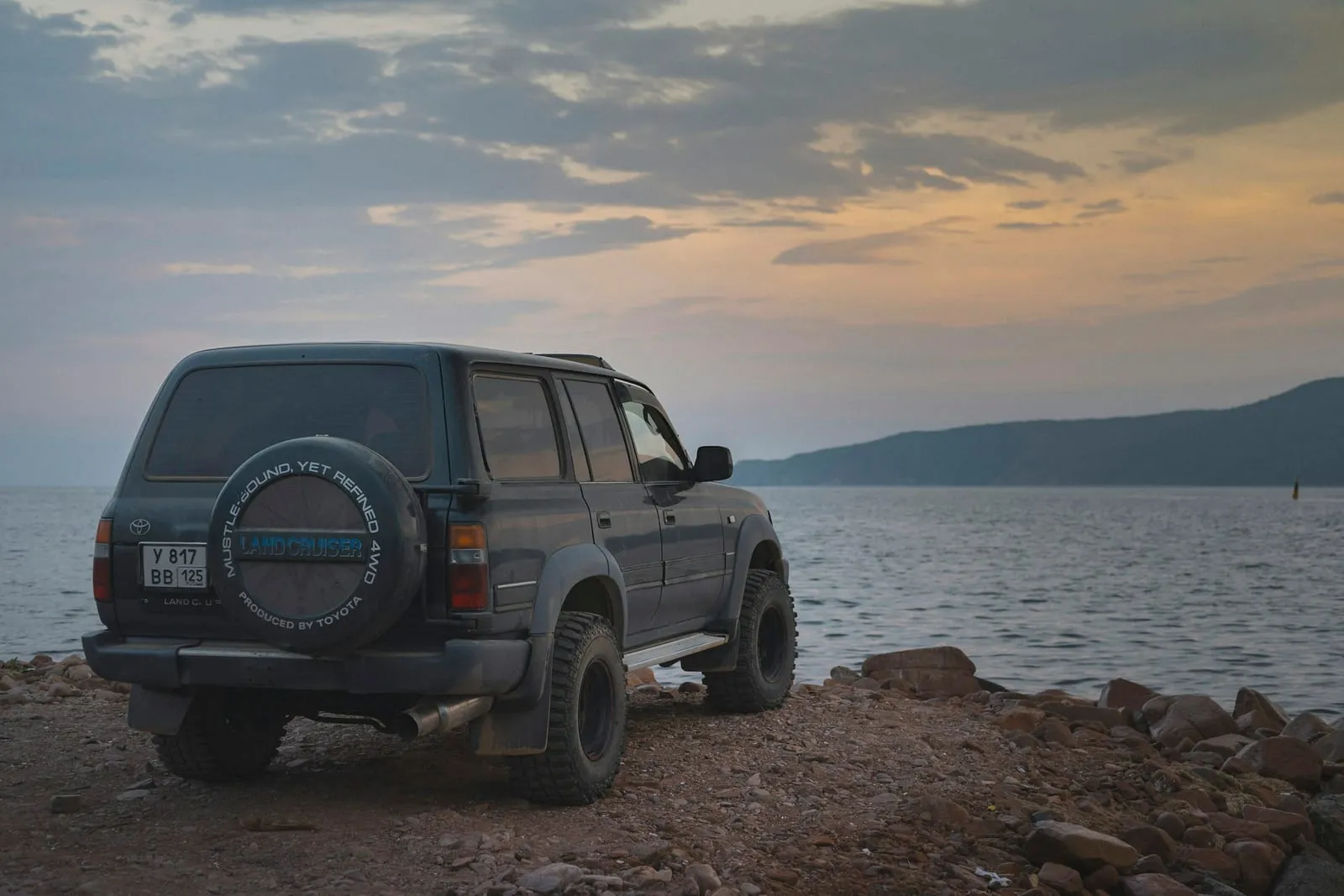 A black suv parked by the water.