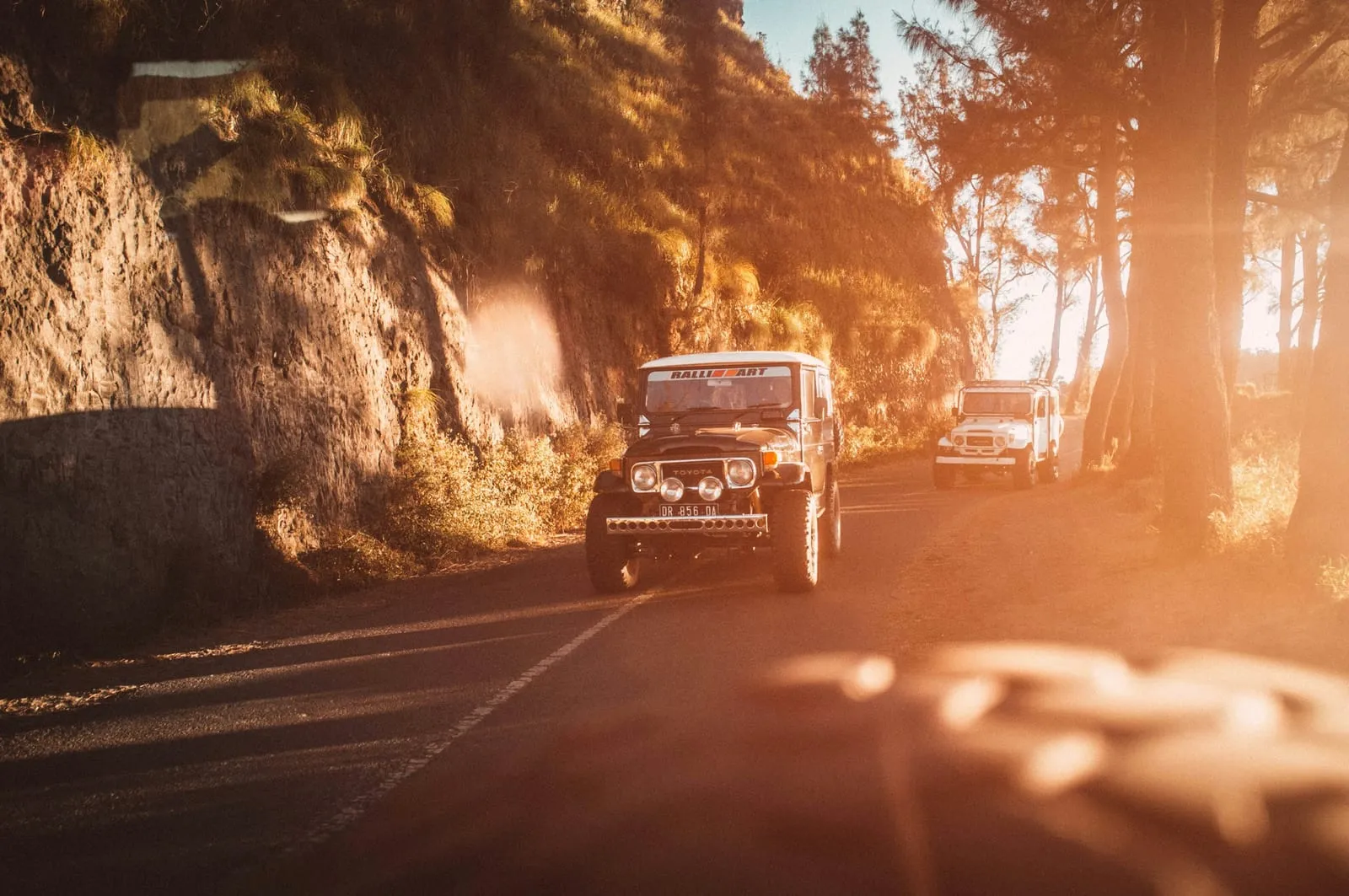 red suv on road during sunset